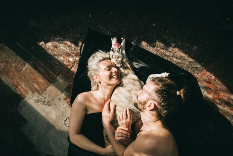 couple lying down and hugging their dog